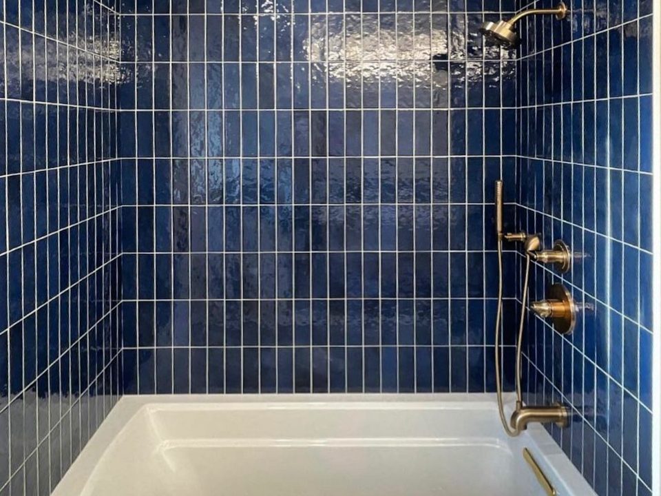Blue tile tub surround with shower fixtures