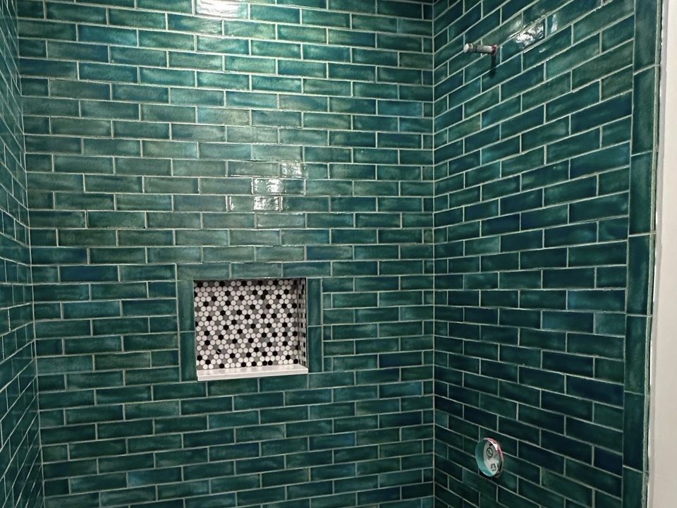 Green shower wall tile with a patterned niche