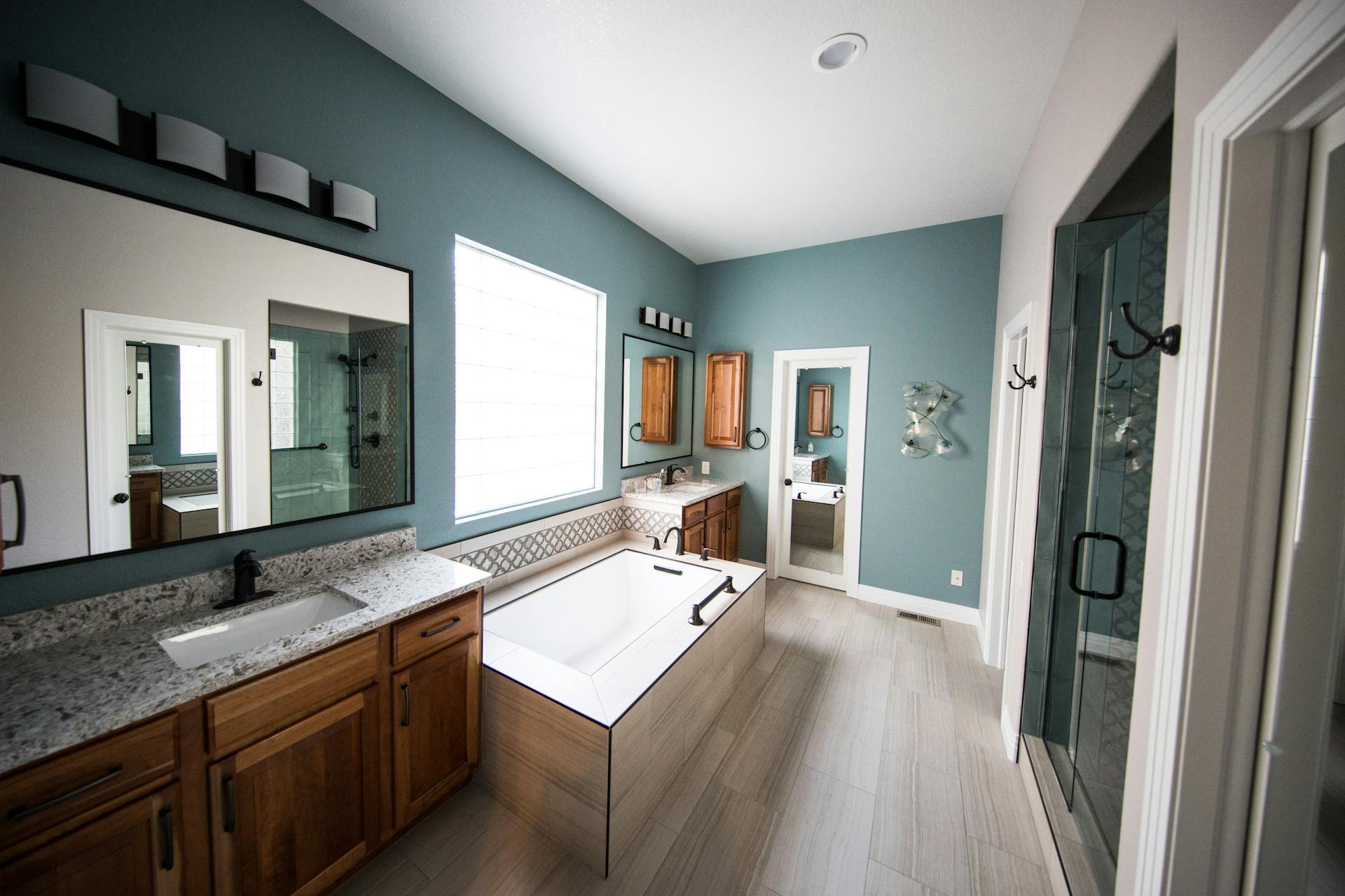 Tiled walk-in shower with frameless glass and double vanity