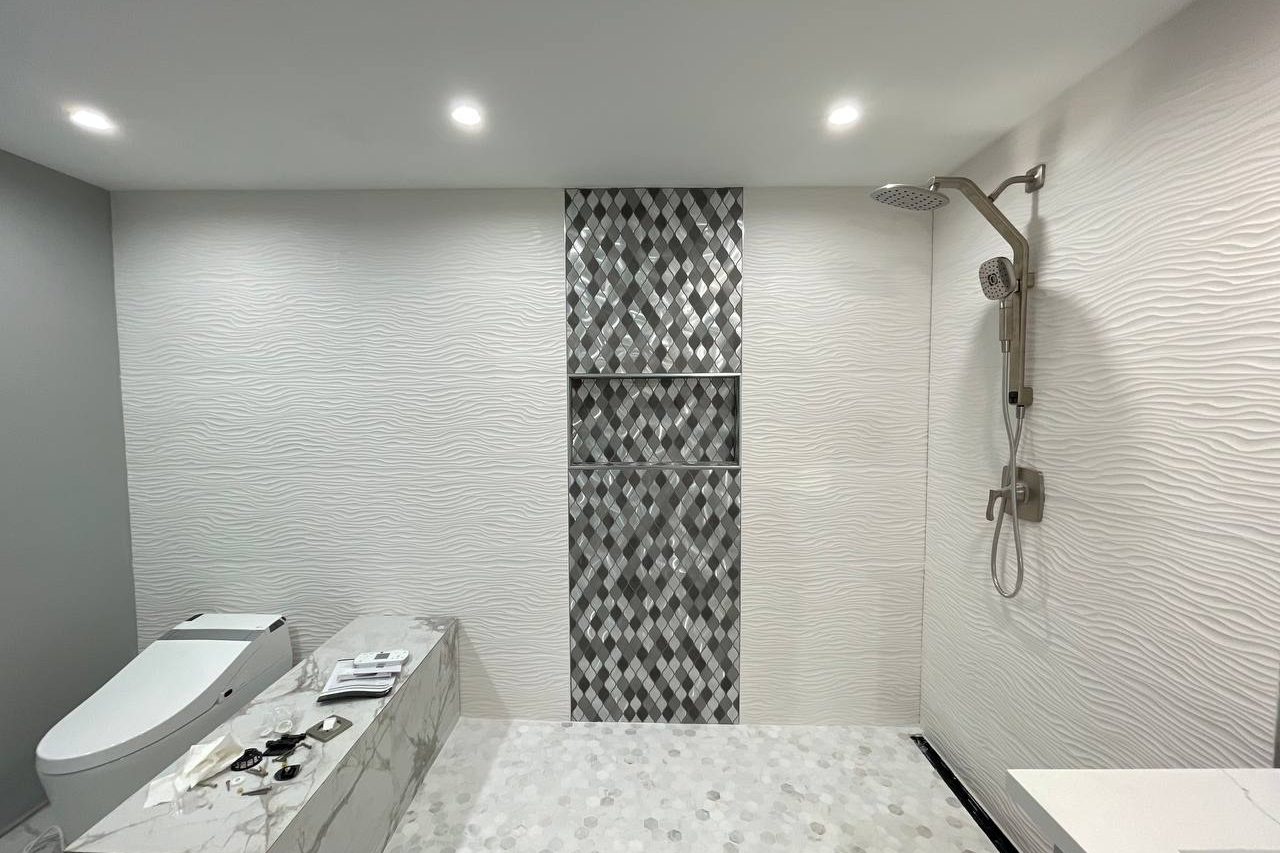 Tiled walk-in shower with accent tile niche and textured wall tile